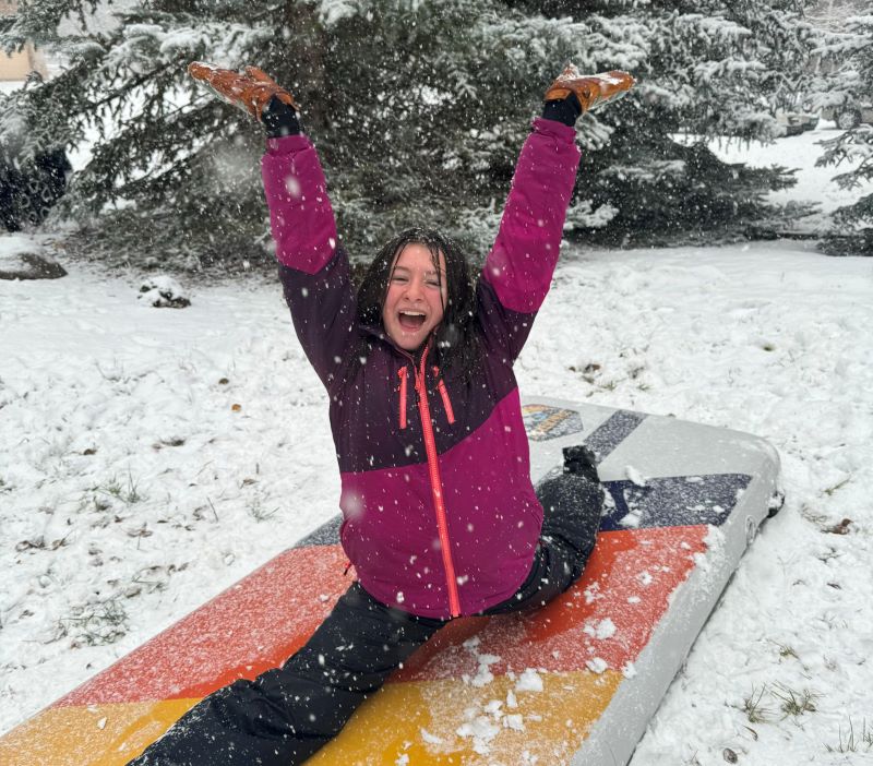 girl doing splits on Adventure Board in snow